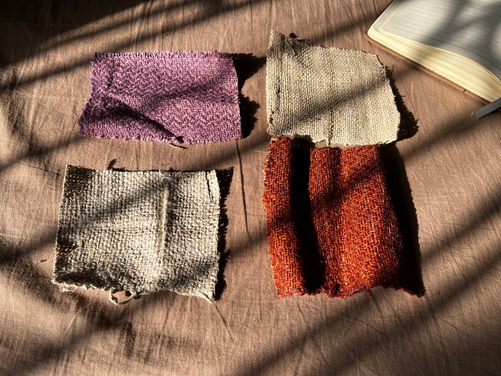 Four handwoven hemp fabric swatches showing different weaves and dye colours.