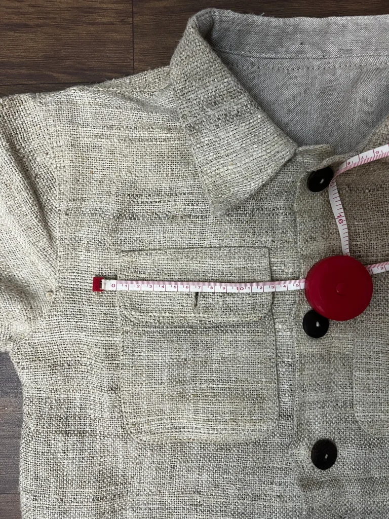 Tape across the flap chest pocket of a handwoven hemp chore jacket